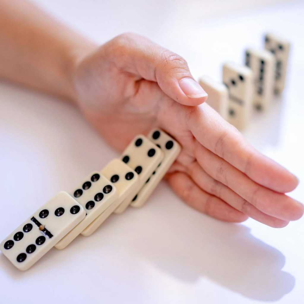 woman hand stopping domino dice